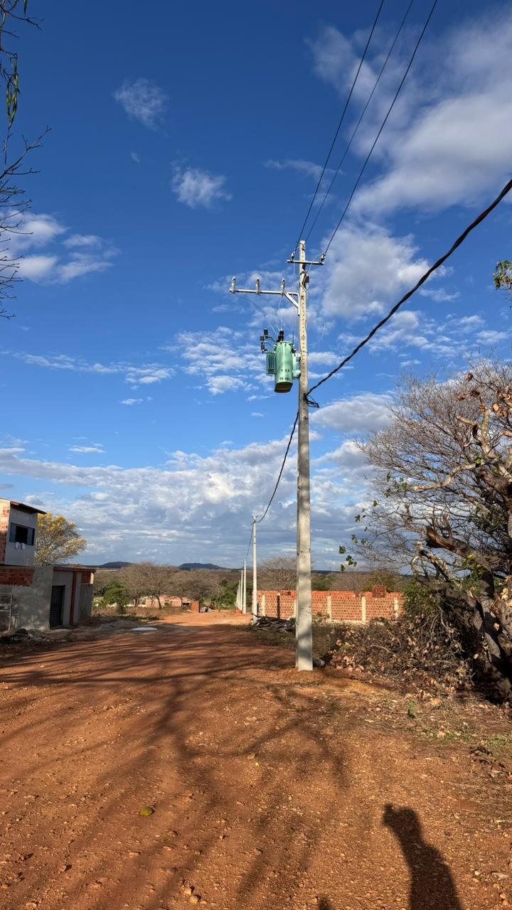 Poste com transformador e rede elétrica instalada em uma rua do loteamento
